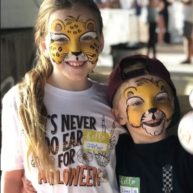 Two children in leopard and lion face painting