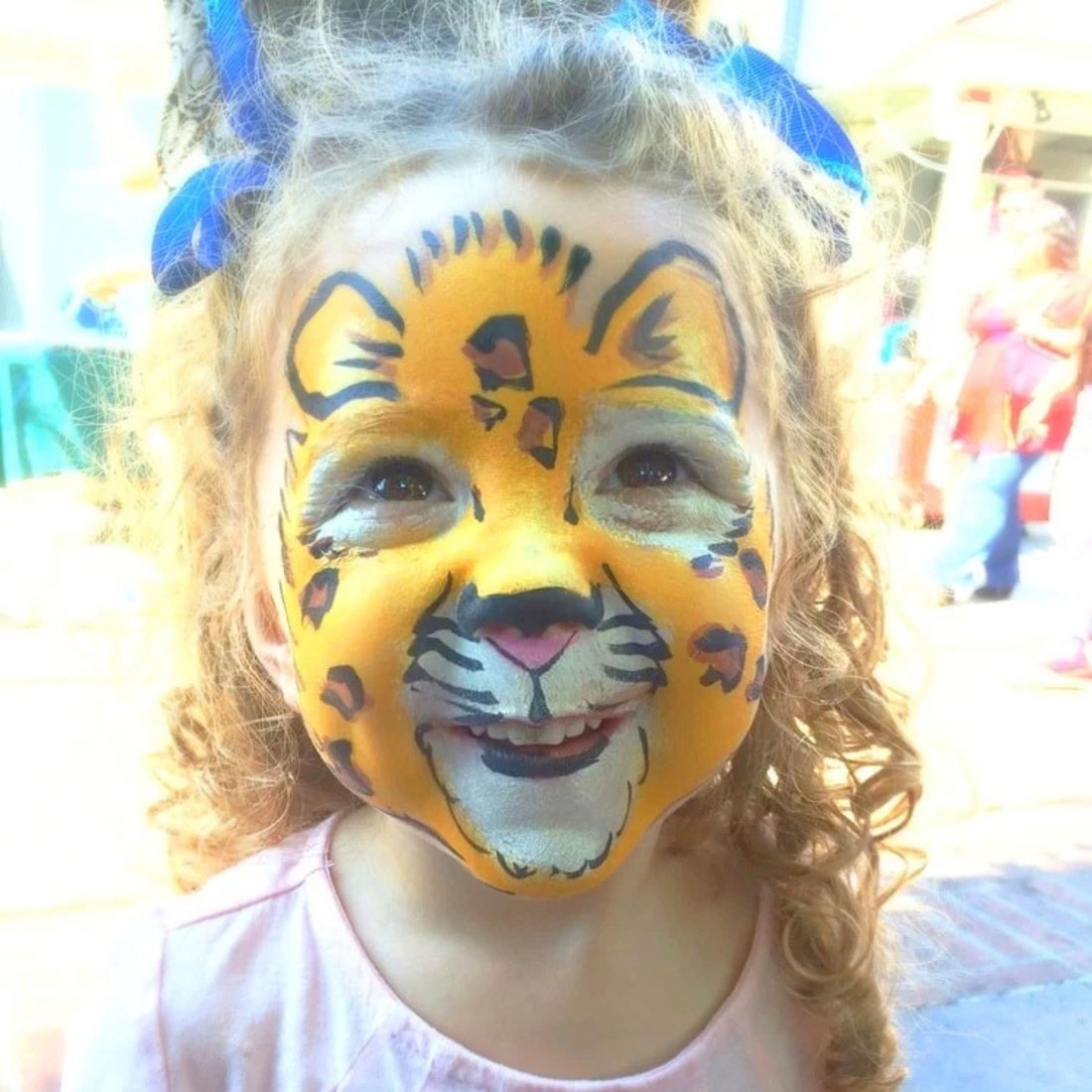 A girl in tiger face painting by a Taylor Entertainment Inc. face painter